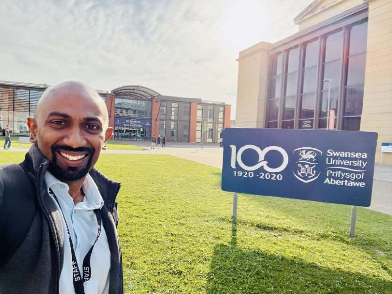 Dr. Angelo at Swansea University centenary sign
